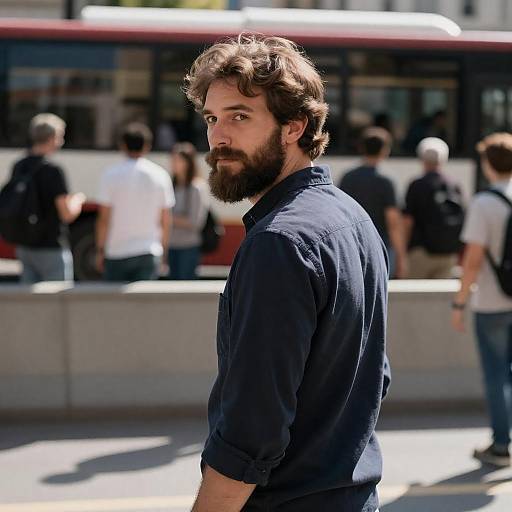 Bearded Man Looking Over Shoulder at Bus Stop