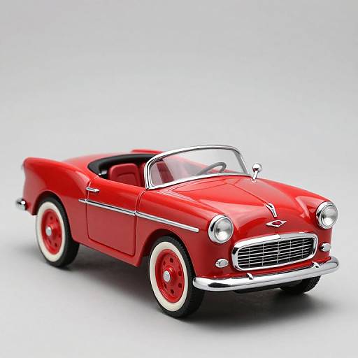 Photograph of a vibrant red classic convertible car with white-walled tires, chrome accents, and a sleek, retro design against a white background.