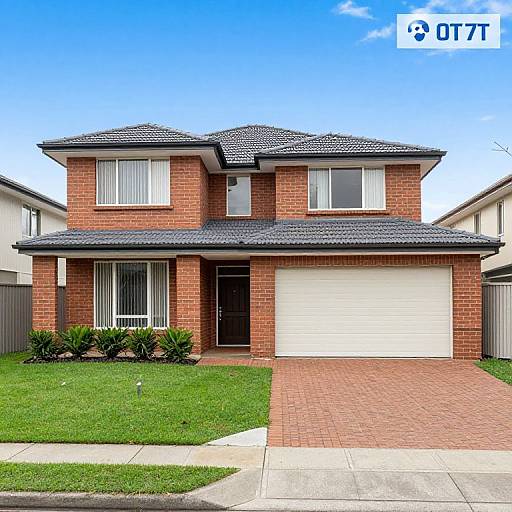 Photograph of a two-story suburban brick house with a gray shingle roof, white garage door, and neatly trimmed lawn. Bright blue sky with a