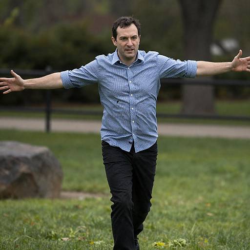 Man running in park with arms outstretched