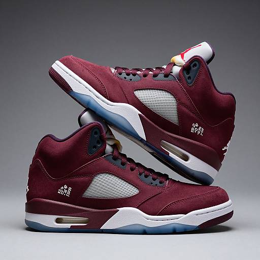 Photograph of stylish, maroon high-top sneakers with white mesh panels, blue accents, and gold details, positioned against a gradient gray background.