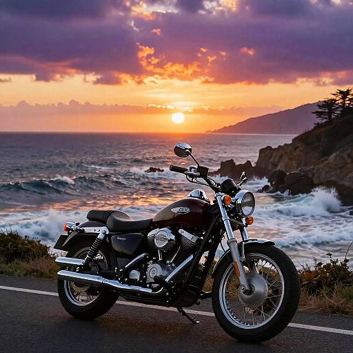 Photograph of a black motorcycle with chrome accents parked on a coastal road, overlooking a dramatic sunset over the ocean and rocky shoreline.