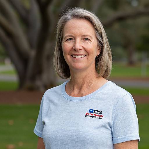 Photograph of a smiling middle-aged woman with gray hair, wearing a white BCCA 