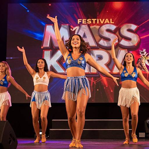 Photograph of four smiling cheerleaders performing on stage at 