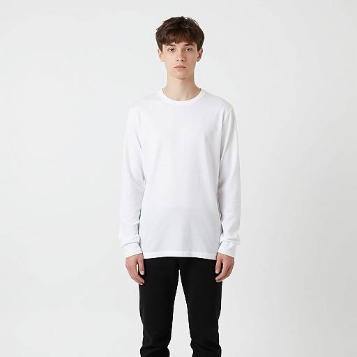 Photograph of a young man with short brown hair, wearing a white long-sleeve shirt and black pants, standing against a plain white background.