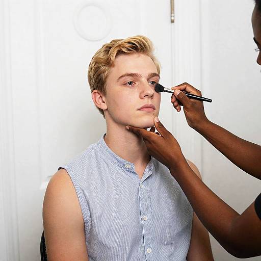 Young Man Getting Makeup Application Indoors