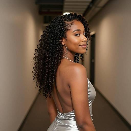 Black woman with curly hair in silver backless top