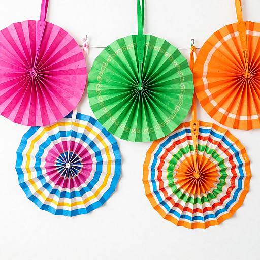 Photograph of six colorful paper parasols in pink, green, orange, multicolored, blue, and rainbow patterns, hanging against a white background