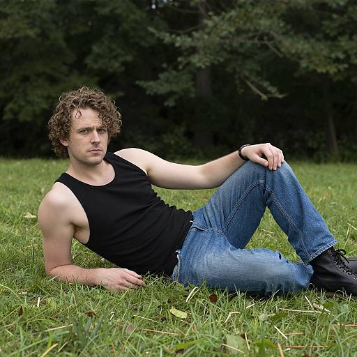 Man Relaxing on Grass in Black Tank Top