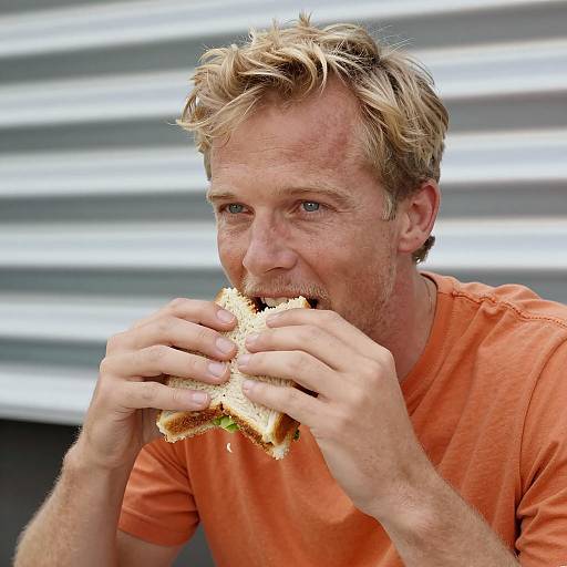 Man Enjoying Sandwich in Industrial Setting