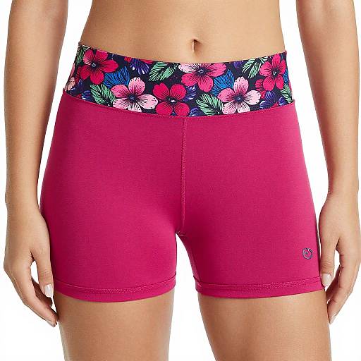 Photograph of a person's midsection wearing red shorts with a colorful cherry and leaf pattern waistband, standing against a plain white background.