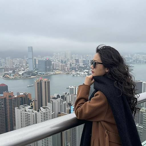 Woman overlooking foggy cityscape from balcony