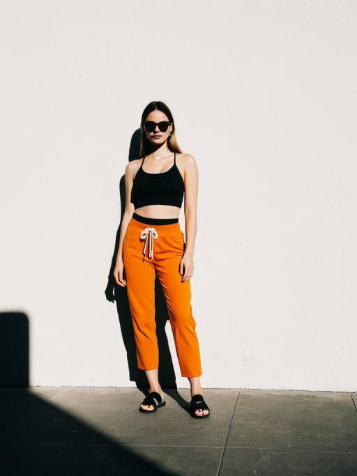 Sporty Woman in Black Crop Top and Orange Pants