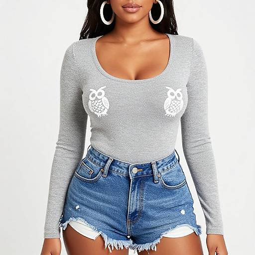 Photograph of a woman with light brown skin, wearing a gray, long-sleeve, low-cut top with white owl designs, and high-w