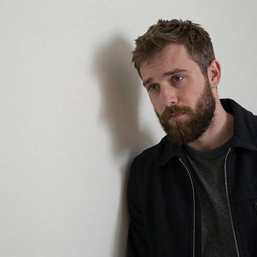 Concerned Bearded Man Leaning on Wall