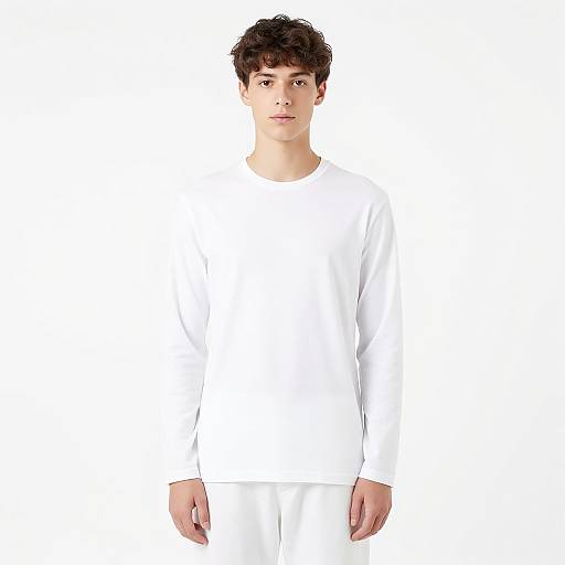 Photograph of a young man with short, curly brown hair, wearing a plain white long-sleeve shirt and white pants, standing against a pure