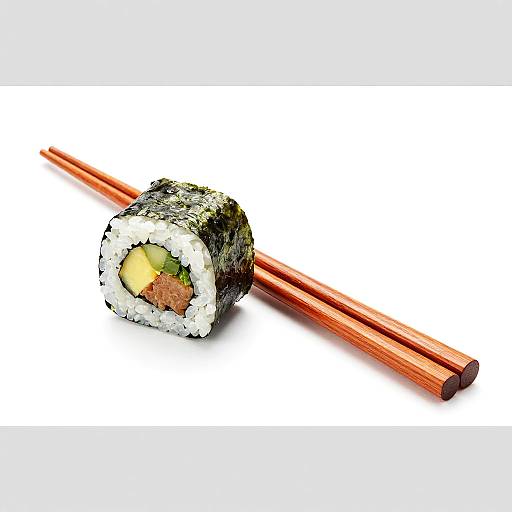 Photograph of a sushi roll with nori, rice, yellow tamago, and green filling, accompanied by red wooden chopsticks on white background.