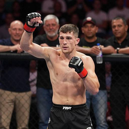 Male MMA Fighter Raising Fists in Octagon