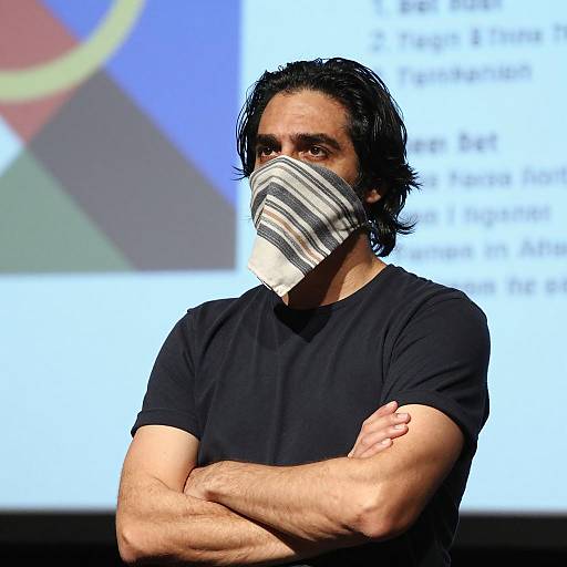 Man Wearing Striped Cloth Face Covering with Arms Crossed