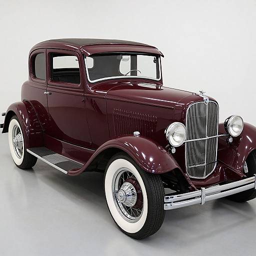 Photograph of a classic, glossy dark maroon vintage car with white-walled tires, chrome grille, and side mirrors, displayed against a white background