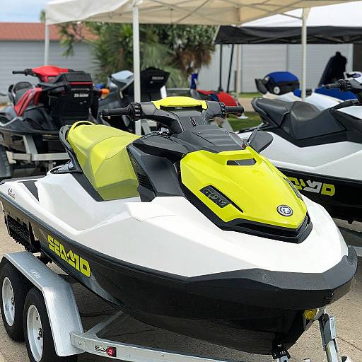 Photograph of a bright yellow and white Yamaha jet ski with black accents, parked outdoors under white tents, surrounded by other jet skis.