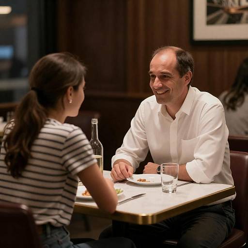 Middle-Aged Man Smiles Across Restaurant Table