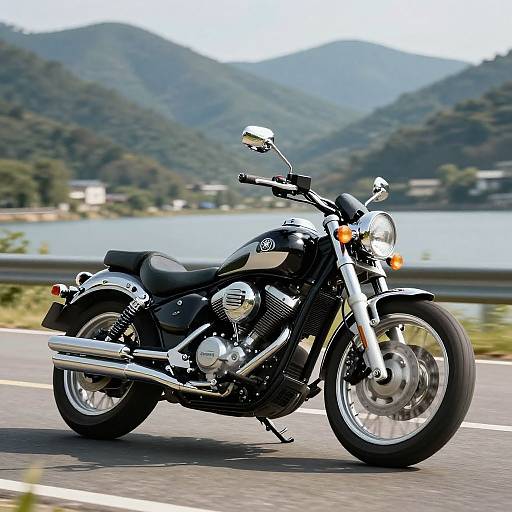 Photograph of a sleek black Harley-Davidson motorcycle with chrome accents, riding on a road with a mountainous, lakeside backdrop.