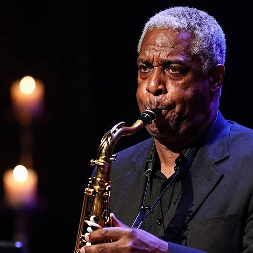 Photograph of a middle-aged Black man with short gray hair, wearing a black suit and black shirt, passionately playing a golden saxophone on stage,