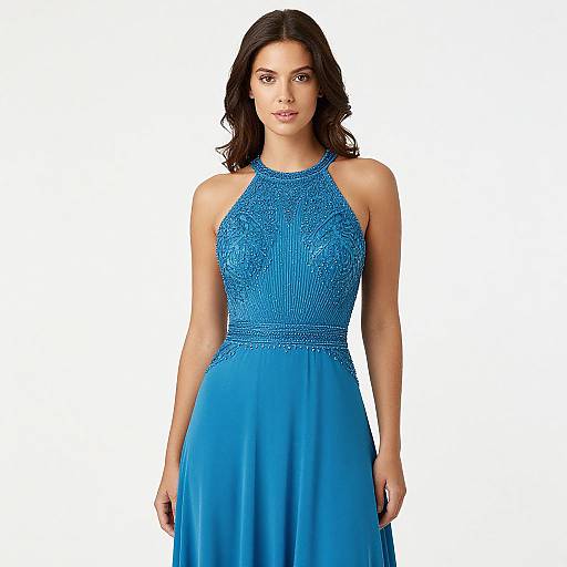 Photograph of a dark-haired woman in a vibrant blue, halter-neck, sleeveless gown with intricate beadwork on the bodice. White background