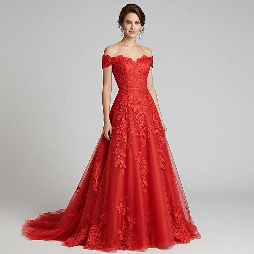 Photograph of a woman in an off-the-shoulder, floor-length, red lace gown with a floral pattern, standing against a plain white background