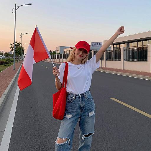 Young woman holding red and white flag on empty road