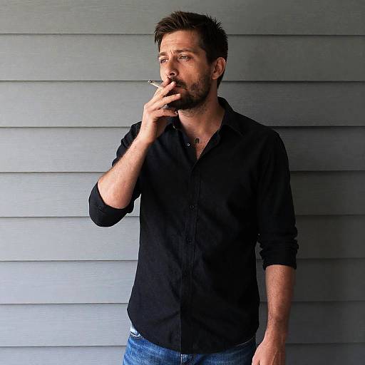Casual Man Smoking Against Gray Siding