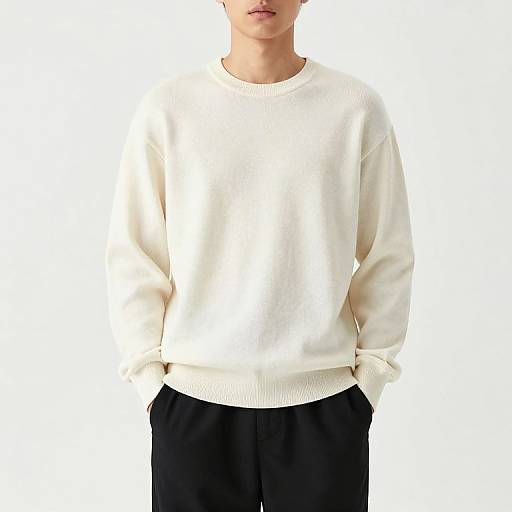 Photograph of a person wearing a plain white sweatshirt with black pants, hands in pockets, head partially cropped, white background.