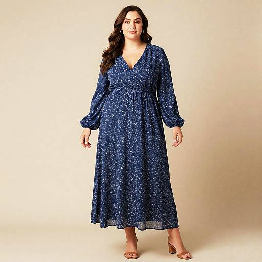 Photograph of a plus-size woman with long dark hair, wearing a blue, floral-patterned, V-neck dress with long sleeves, standing against a