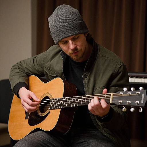 Man Playing Guitar in Dim Room