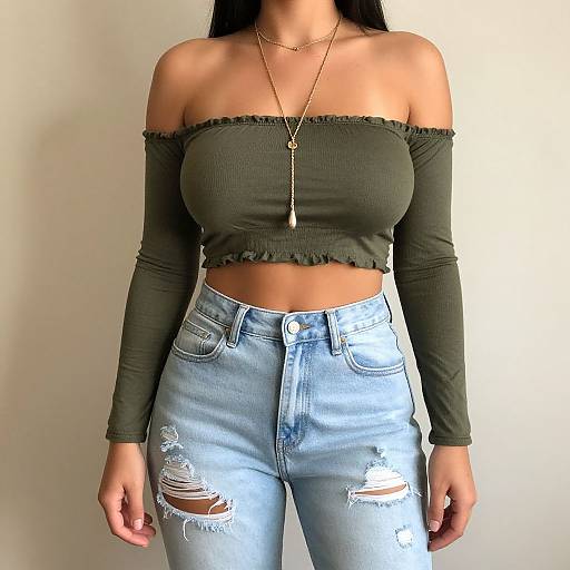 Photograph of a woman with long black hair, wearing an off-shoulder green crop top and high-waisted, ripped blue jeans, against