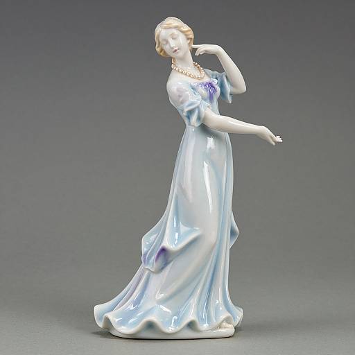 Photograph of a white porcelain statue of a graceful woman in a flowing, iridescent blue and white gown, posing elegantly against a gray background
