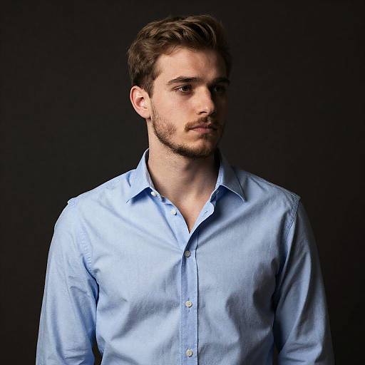 Young Man in Light Blue Shirt Against Dark Background