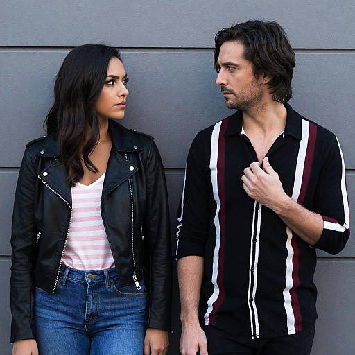 Young couple standing against gray wall