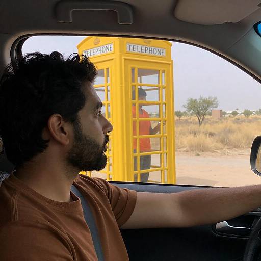 Man in Car with Desert and Telephone Booth