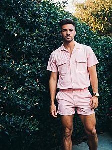 Man Wearing Pink Romper With Shirt and Shorts Standing Outdoors