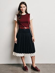 Young Woman in Burgundy Top and Pleated Black Skirt with Lace Detail