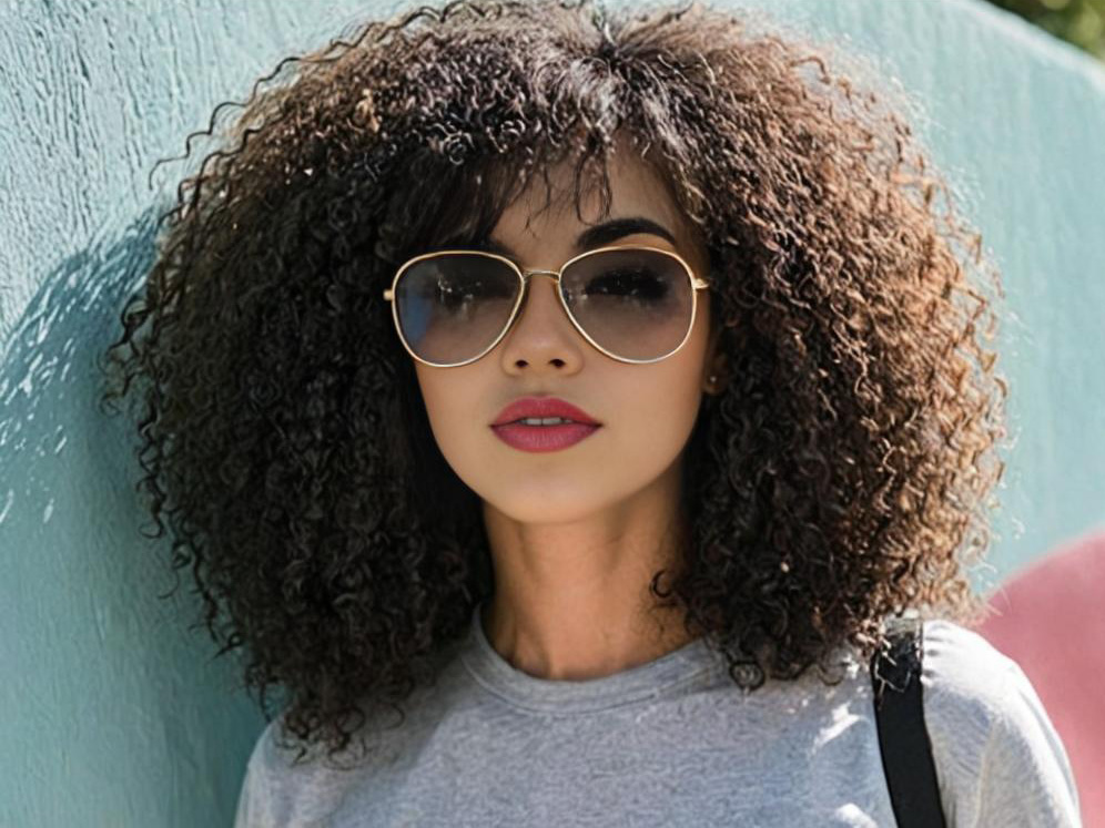 Stylish woman with curly hair and sunglasses