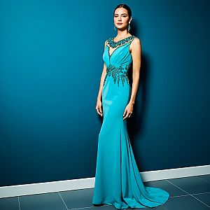 Elegant Woman in Turquoise Gown Against Blue Wall
