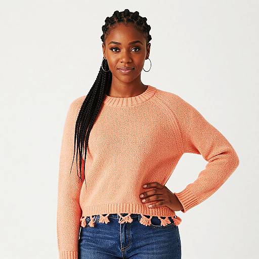 Young Woman in Peach Knitted Sweater with Tassel Detail and Blue Jeans