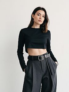 Woman in Contemporary Minimalist Black Asymmetrical Crop Top with Long Sleeves and High-Waisted Gray Trousers
