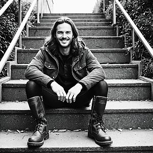 Man with Long Hair and Beard Sitting on Steps