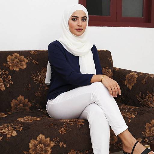 Woman in White Hijab and Navy Blue Top Sitting on Floral Sofa