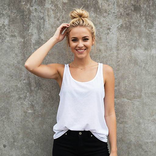 Casual Gen Z Woman Smiling in White Tank Top Against Concrete Wall