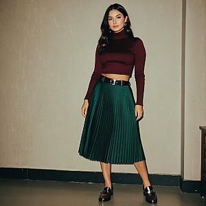 Stylish Woman in Burgundy Crop Top and Green Pleated Skirt